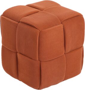 Close-up view of soft corduroy ottoman footrest with textured woven design in rust orange color.”