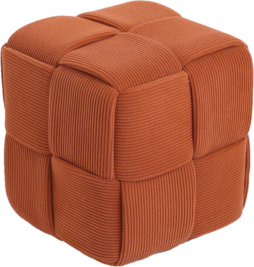 Close-up view of soft corduroy ottoman footrest with textured woven design in rust orange color.”