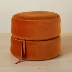 round pouf upholstered footrest Rust-colored round pouf ottoman with upholstered fabric and stackable cushion layers